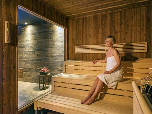 a woman is sitting in a sauna at BAD MOOS - Aqua Spa Resort in Sesto