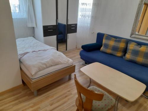 ein Wohnzimmer mit einem blauen Sofa und einem Tisch in der Unterkunft Classic Appartments in Knittelfeld