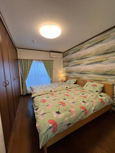 1 dormitorio con 1 cama con un edredón colorido en 舟荘 en Osaka