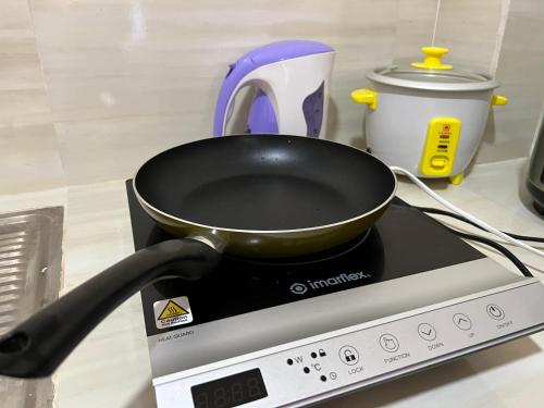 a frying pan on top of a stove at Reinhardshausen Suites and Residences - Cozy Air-conditioned Units in Tuguegarao City