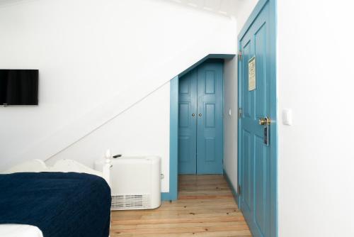 a bedroom with blue doors and wooden floors at Des Arts in Amarante