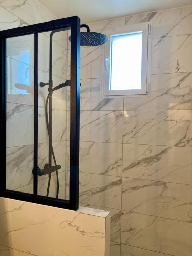 La salle de bains est pourvue d'une douche et d'une fenêtre. dans l'établissement Appartement avec terrasse et parking gratuit accolé, à Montbéliard