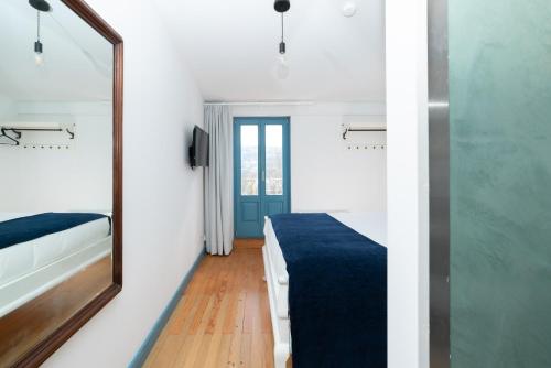 a small room with a mirror and a bed at Des Arts in Amarante