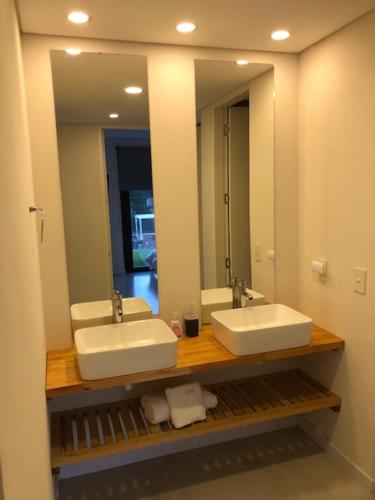 baño con 2 lavabos y espejo grande en casas barrio cerrado costa esmeralda en Pinamar