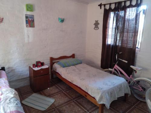 um quarto com uma cama e uma bicicleta em Casa en Sierras del Mar em Cuchilla Alta