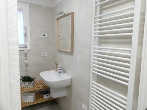 een witte badkamer met een wastafel en een spiegel bij Casa Mavi Treviso in Treviso