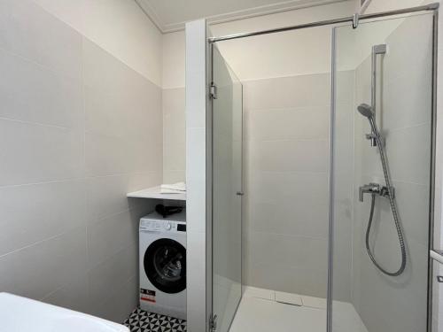 um chuveiro na casa de banho com uma máquina de lavar roupa em Nature in the City upper storey Bestern em Szeged