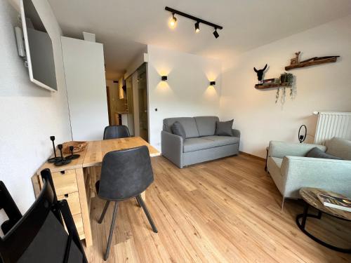 ein Wohnzimmer mit einem Tisch und einem Sofa in der Unterkunft Alpen Studio Ellmau in Ellmau
