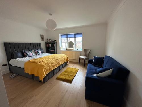 1 dormitorio con 1 cama y 1 sofá azul en Family & pet friendly house + private garden en Oakhill