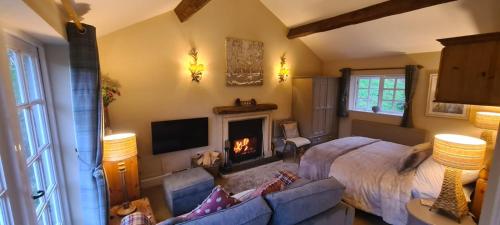 a living room with a bed and a fireplace at The Hideaway in Shepton Mallet