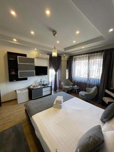 ein Schlafzimmer mit einem großen Bett und ein Wohnzimmer in der Unterkunft Ami Residence Bucharest Airport,Therme&FREE PARKING Otopeni in Otopeni