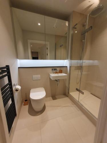 a bathroom with a toilet and a shower and a sink at Lovely 2Bedroom Apartment in Manchester