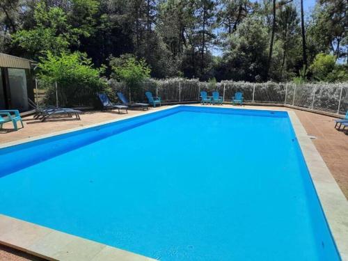 une piscine bleue avec des chaises et une clôture dans l'établissement Appartement T3 * * * + Piscine, à La Tranche-sur-Mer