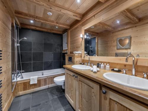 une salle de bain avec deux lavabos et une baignoire et des toilettes dans l'établissement Chalet familial à Courchevel, proche centre et pistes, avec sauna et jacuzzi - FR-1-562-54, à Courchevel