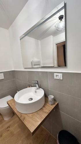 a bathroom with a sink and a mirror and a toilet at Centro Storico Caruggi 2min Acquario Pellicceria Superior Loft Palazzo Rolli in Genova