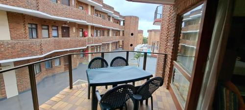 a balcony with a table and chairs on a building at See Uitsig 16 in Uvongo Beach