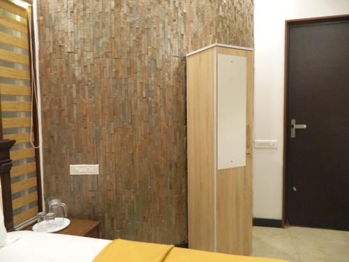 1 dormitorio con puerta de madera y pared marrón en Torch Ginger Homestay en Sultan Bathery