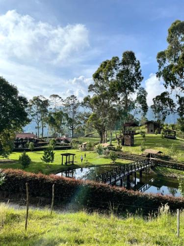 a bridge over a pond in a park at El Agrado Restaurante Cabañas in Líbano