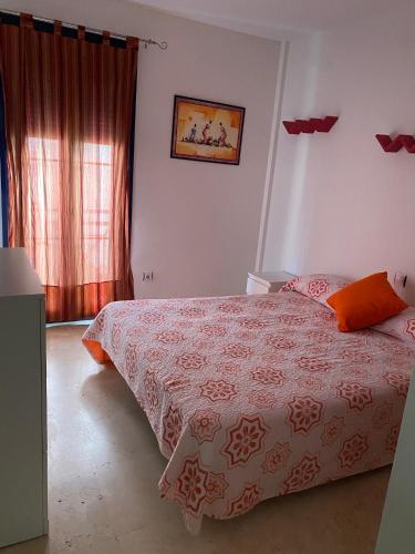 a bedroom with a bed with a red and white blanket at Palm mar Relax House in Palm-Mar