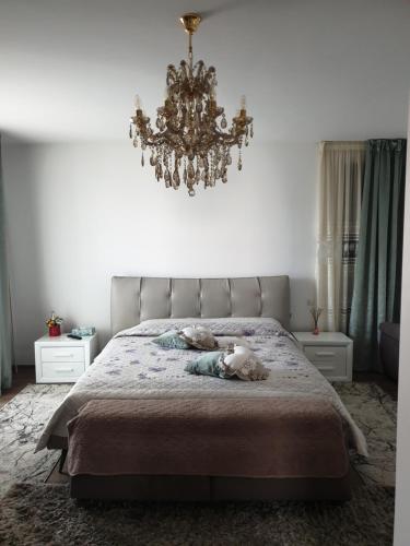 a bedroom with a large bed with a chandelier at Panorama penthouse in Şelimbăr