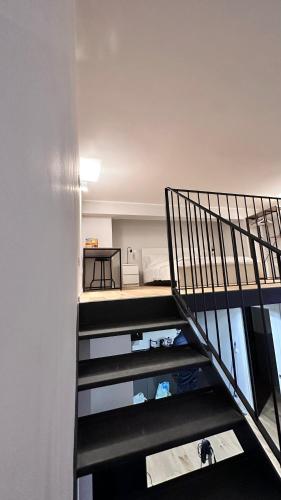 a spiral staircase leading to a room with a bed at Centro Storico Caruggi 2min Acquario Pellicceria Superior Loft Palazzo Rolli in Genova