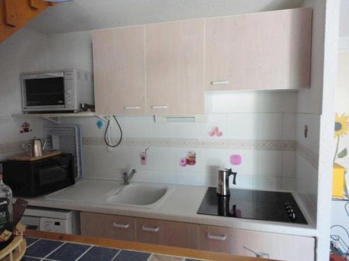 une cuisine avec un évier et un micro-ondes dans l'établissement GOLF CLUB RESIDENCE Joli T3 villa mitoyenne proche golf Richelieu Cap d'Agde, au Cap d'Agde