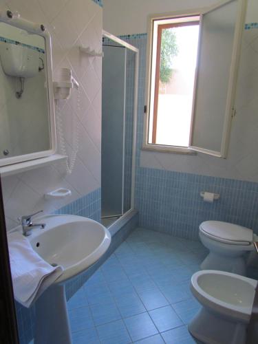 a bathroom with a sink and a toilet and a window at Residence Villalba in Lampedusa