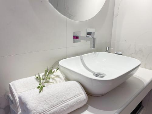 a white bathroom with a sink and a towel at Sunrise Luxury House in Pefkochori
