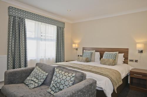 a hotel room with two beds and two lamps at The Kinmel & Kinspa in Abergele