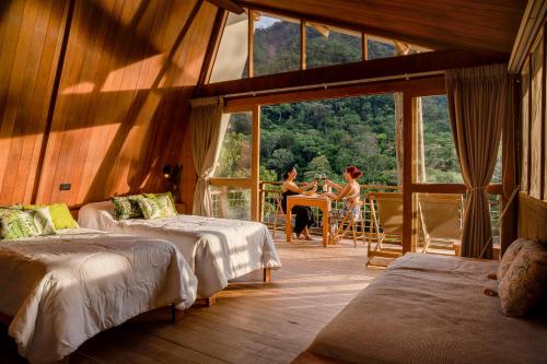 two women sitting at a table in a room with windows at Pumarinri Amazon Lodge in Tarapoto