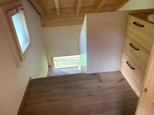 Zimmer im Dachgeschoss mit Holzschränken und einem Fenster in der Unterkunft Casa Valtgeva in Sedrun