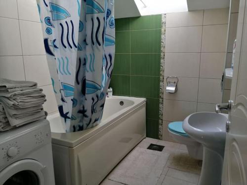 a bathroom with a toilet and a shower curtain at Apartman Nataša 3 in Vršac