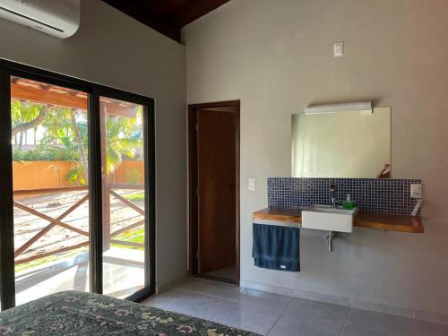 baño con lavabo, espejo y ventana en Fabulous 5 bedroom villa in Japaratinga, en Japaratinga