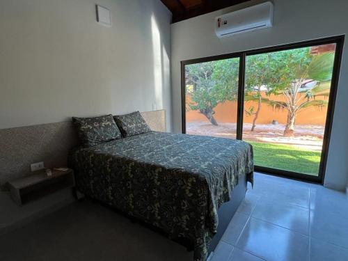 1 dormitorio con cama y ventana grande en Fabulous 5 bedroom villa in Japaratinga, en Japaratinga