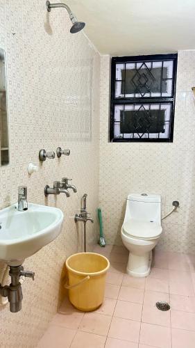 a bathroom with a sink and a toilet and a window at Muffys Holiday Villa in Old Goa