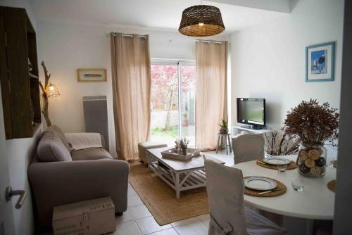 a living room with a couch and a table at Appart cosy 4/6 personnes idéalement placé in Aytré
