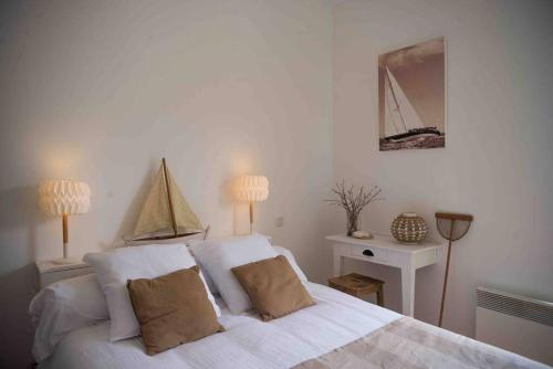 1 dormitorio con 1 cama blanca grande y 2 almohadas en Appart cosy 4/6 personnes idéalement placé, en Aytré