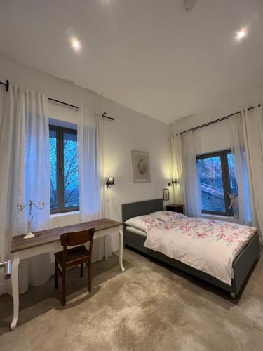 una camera da letto con un letto, una scrivania e finestre di Historisches Designer Loft a Essen
