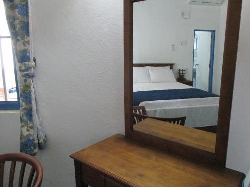 a bedroom with a bed and a mirror on a table at Villa Whispering Shells in Kalutara