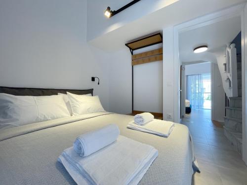 a bedroom with a white bed with towels on it at Sunrise Luxury House in Pefkochori