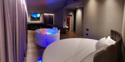 een kamer met een bad met een tafel en een tv bij Leoni Hotel & Private Spa - LOVE HOTEL in Città Sant'Angelo