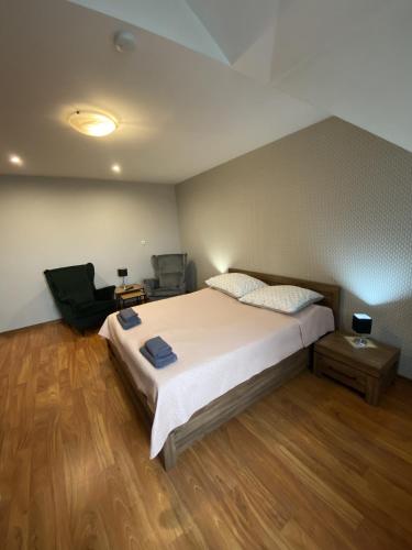 a bedroom with a large bed and a chair at Restauracja Zacisze Leśne Noclegi in Knurów