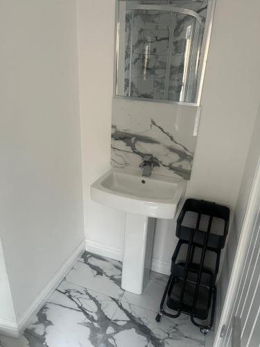 a bathroom with a sink and a mirror at Modern welsh cottage in Porth