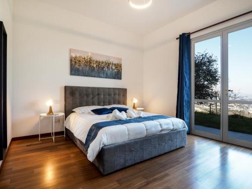 - une chambre avec un lit et une grande fenêtre dans l'établissement Rosa Bianca - 5 minuti dal Centro con Giardino e Parcheggio Privato, à Pérouse
