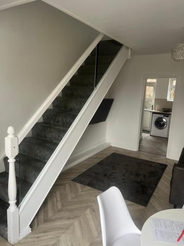 una escalera en una sala de estar con una escalera blanca en Modern welsh cottage en Porth