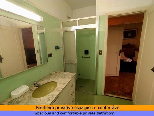 a bathroom with a sink and a mirror and a shower at Suíte Cama Casal Queen Banheiro só seu CGH in Sao Paulo
