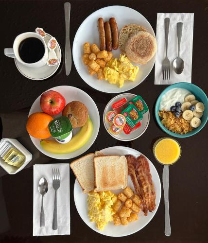 a table with plates of breakfast foods and a cup of coffee at Cloud 9 Inn in Whitecourt