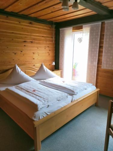 a bed in a room with a wooden wall at Landgasthaus Zum Erlengrund in Emskirchen