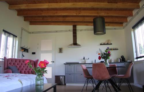 - une chambre avec un lit, une table et des chaises dans l'établissement Bed & Breakfast Bij de Wilg, à Laren