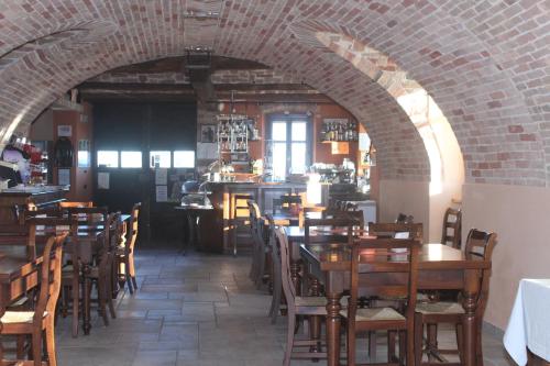 a restaurant with tables and chairs and a brick wall at Il Borgo B&B in Castellinaldo